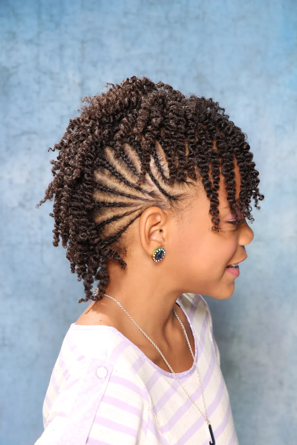 Side view of cornrows flowing into twists on a young client