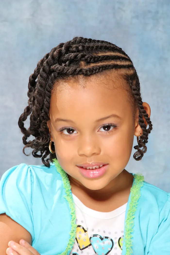 Young client smiling with cornrows and twisted ends, front view