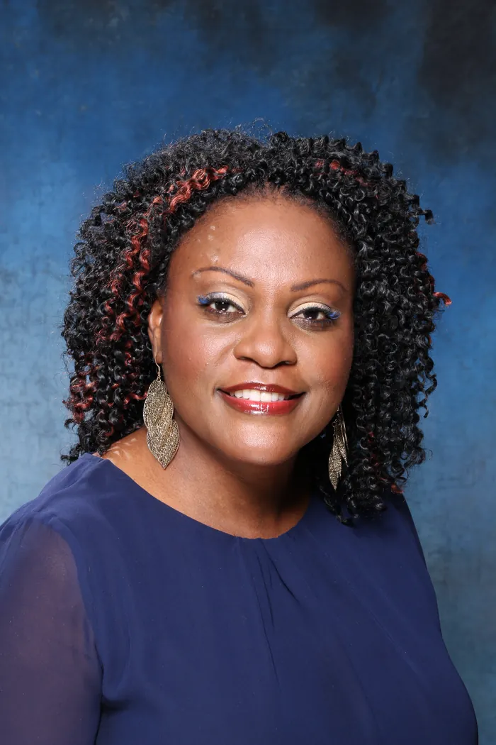 Client smiling with two-strand twists accented in red