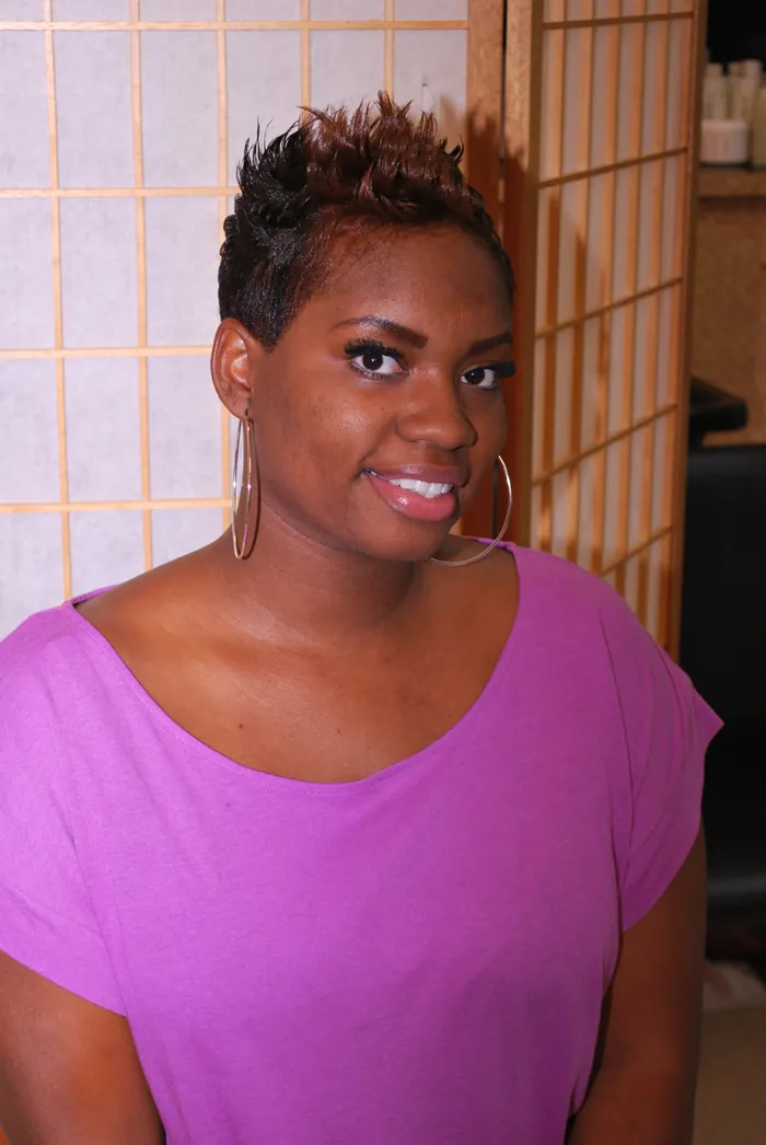 Client in the salon with a short styled natural cut, smiling