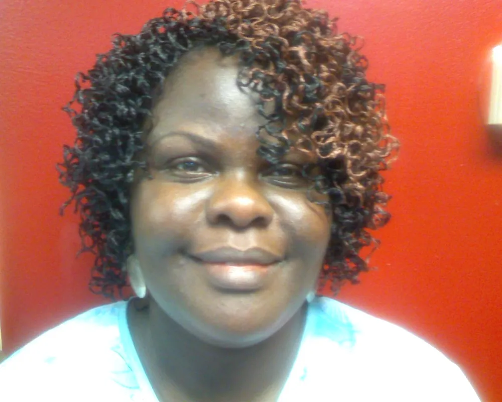 Client with short defined curls smiling, photographed in the salon